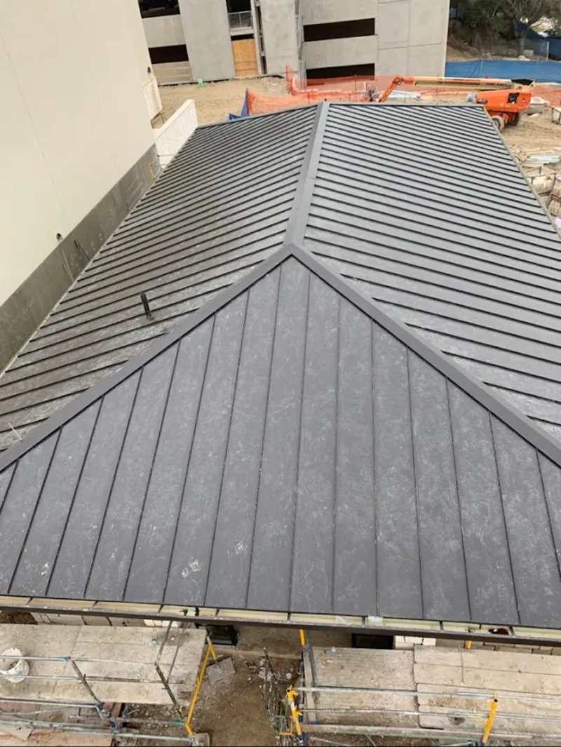 Commercial metal roof construction with crane equipment in Plymouth